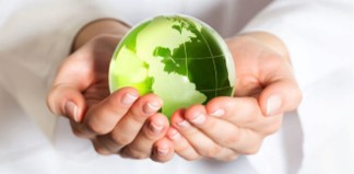 Manos sosteniendo bola del mundo color verde